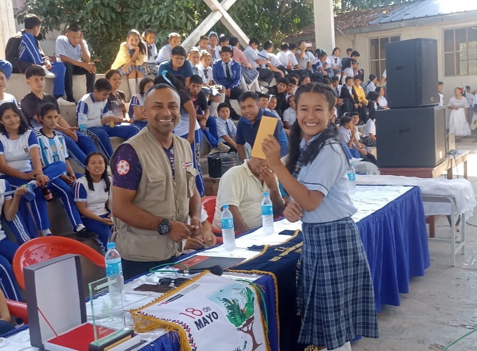 Estudiante ganadora de concurso recibe premio de autoridad local.