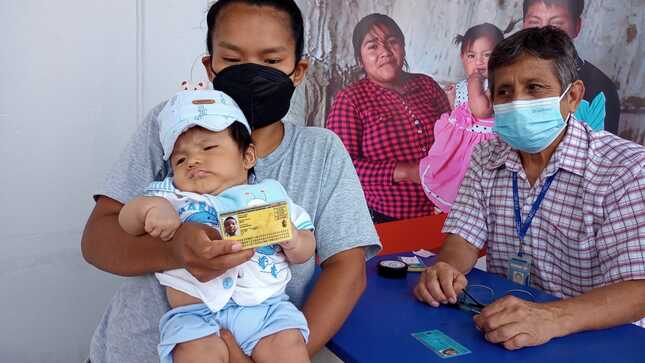 Madre mostrando el DNI de su menor hijo.
