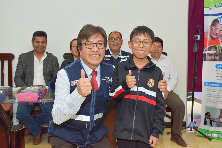 Niño beneficiado posa sonriente con funcionario