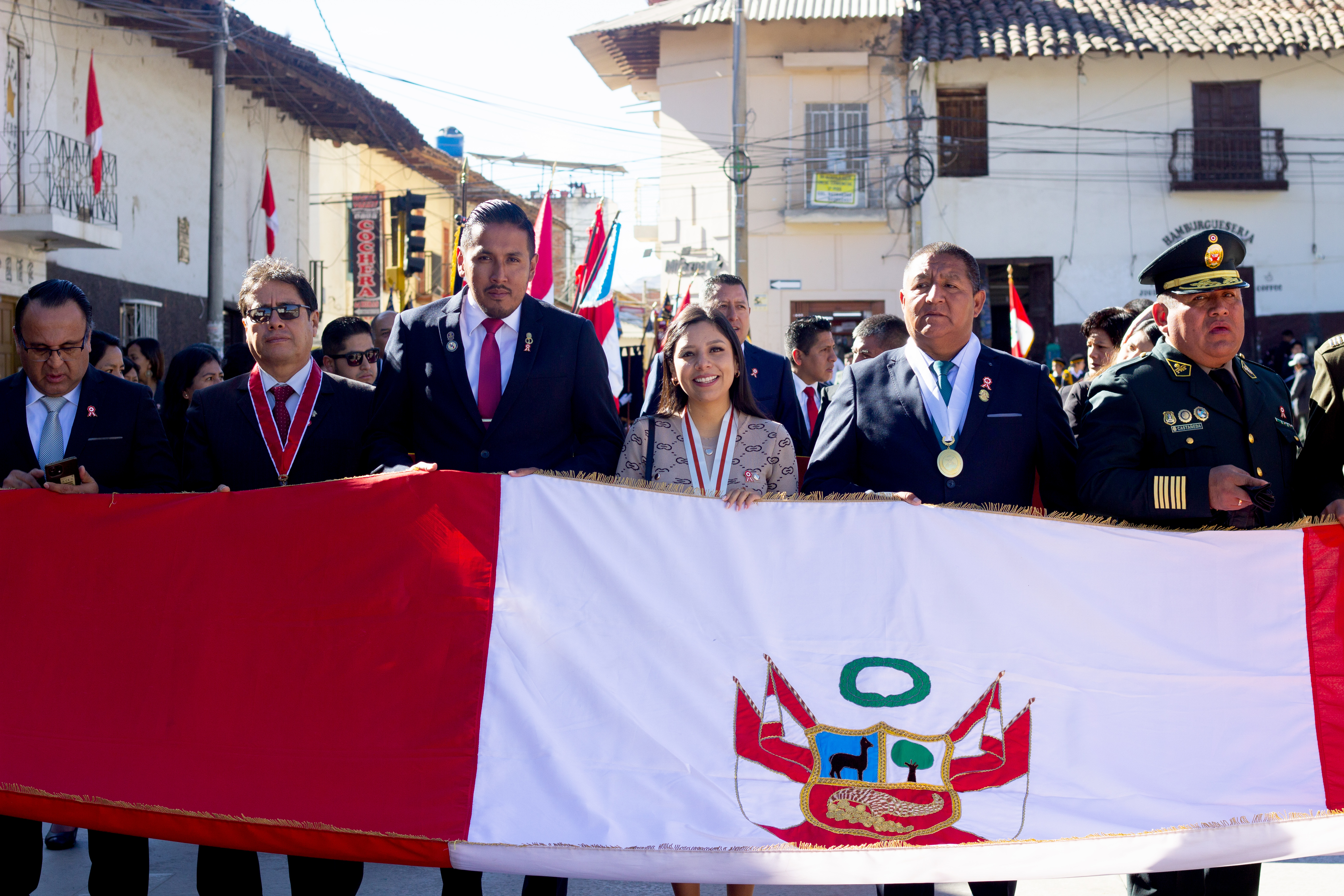 Fotografía de las autoridades locales sosteniendo el pbellón nacional en el paseo de conmemoración por los 140 años de la batalla de Huamachuco.