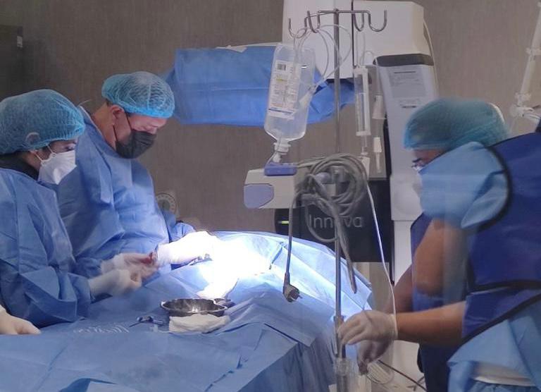 Médicos de la Dirección de Sanidad Policial (Dirsapol) y del Instituto Nacional Cardiovascular “Carlos Alberto Peschiera Carrillo” de EsSalud realizaron con éxito la primera operación de cardiología intervencionista en el Hospital Nacional de la Policía Nacional del Perú "Luis N. Sáenz", ubicado en el distrito de Jesús María.
El procedimiento médico de alta complejidad, denominado cateterismo percutáneo, fue aplicado a una paciente menor de edad de Piura, quien fue diagnosticada con una enfermedad congénita de Conducto Arterioso Persistente.
La operación forma parte de los nuevos servicios que brindará dicho nosocomio a toda la familia policial, gracias a la adquisición de un moderno cineangiógrafo, que es un dispositivo utilizado en el diagnóstico y manejo de las lesiones vasculares cerebrales y permite obtener imágenes digitales multidimensionales en alta calidad en tiempo real.
La incorporación de estas nuevas especialidades médicas obedece a las disposiciones del ministro del Interior, Vicente Romero, y del comando institucional de la Policía Nacional, para optimizar la atención de pacientes y reducir el número de casos que son derivados a otras clínicas o centros de salud.
En la presentación de los resultados de esta intervención médica participaron el titular del sector Interior, Vicente Romero y el comandante general de la PNP, General de Policía Jorge Angulo. También estuvieron presentes el director del Hospital Nacional PNP, Gral. Médico SPNP Moisés Rojas, y el director del Instituto Nacional Cardiovascular de EsSalud, Frank Britto.
El ministro Vicente Romero señaló que el inicio de este tipo de intervenciones de alta cirugía en el Hospital de Policía marca un hito importante en la calidad de la atención médica ofrecida a la familia policial y a la comunidad en general.
“Nos llena de orgullo ver cómo se va concretando este hito significativo para el servicio y la atención de la familia policial. Como autoridad del sector Interior, debo decir que la salud y el bienestar de todos nuestros policías y sus familias tienen alta prioridad para nuestra gestión”, manifestó el ministro.
Indicó que el sector Interior ha suscrito 39 convenios a nivel nacional con gobiernos regionales, institutos especializados, hospitales y centros de salud para que el personal policial y sus derechohabientes puedan recibir una atención adecuada, inmediata y eficiente.