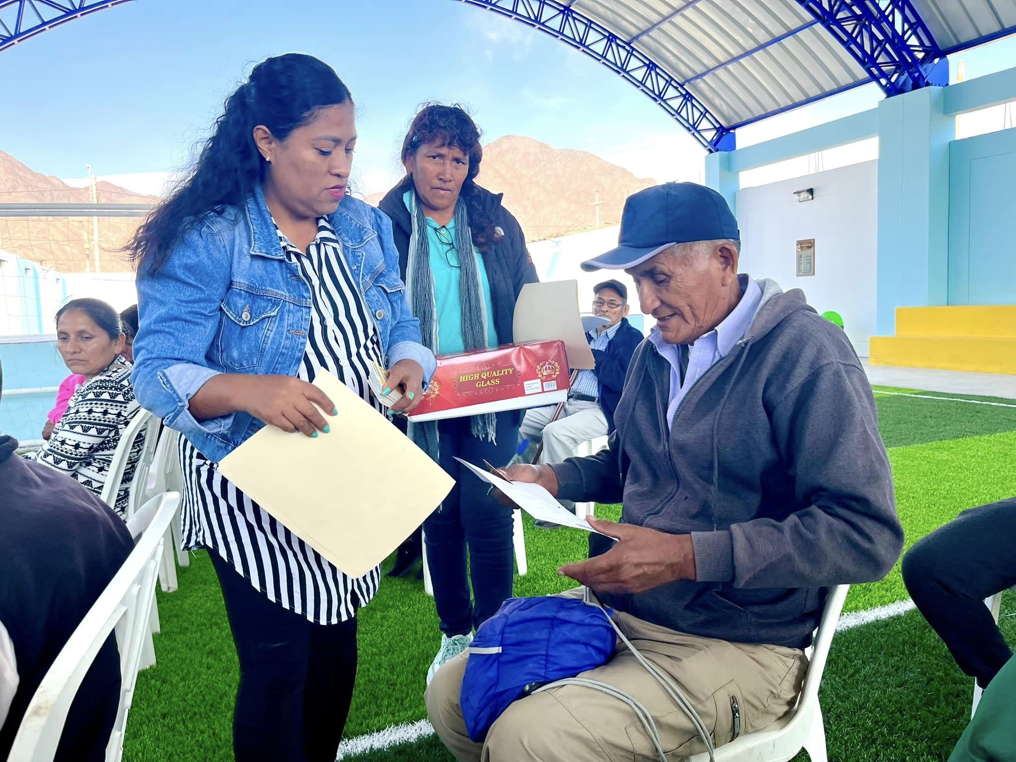 Persona entregando el carnet CONADIS a una persona mayor