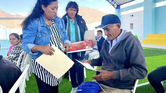 Persona entregando el carnet CONADIS a una persona mayor