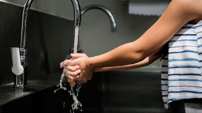persona lavándose las manos con agua