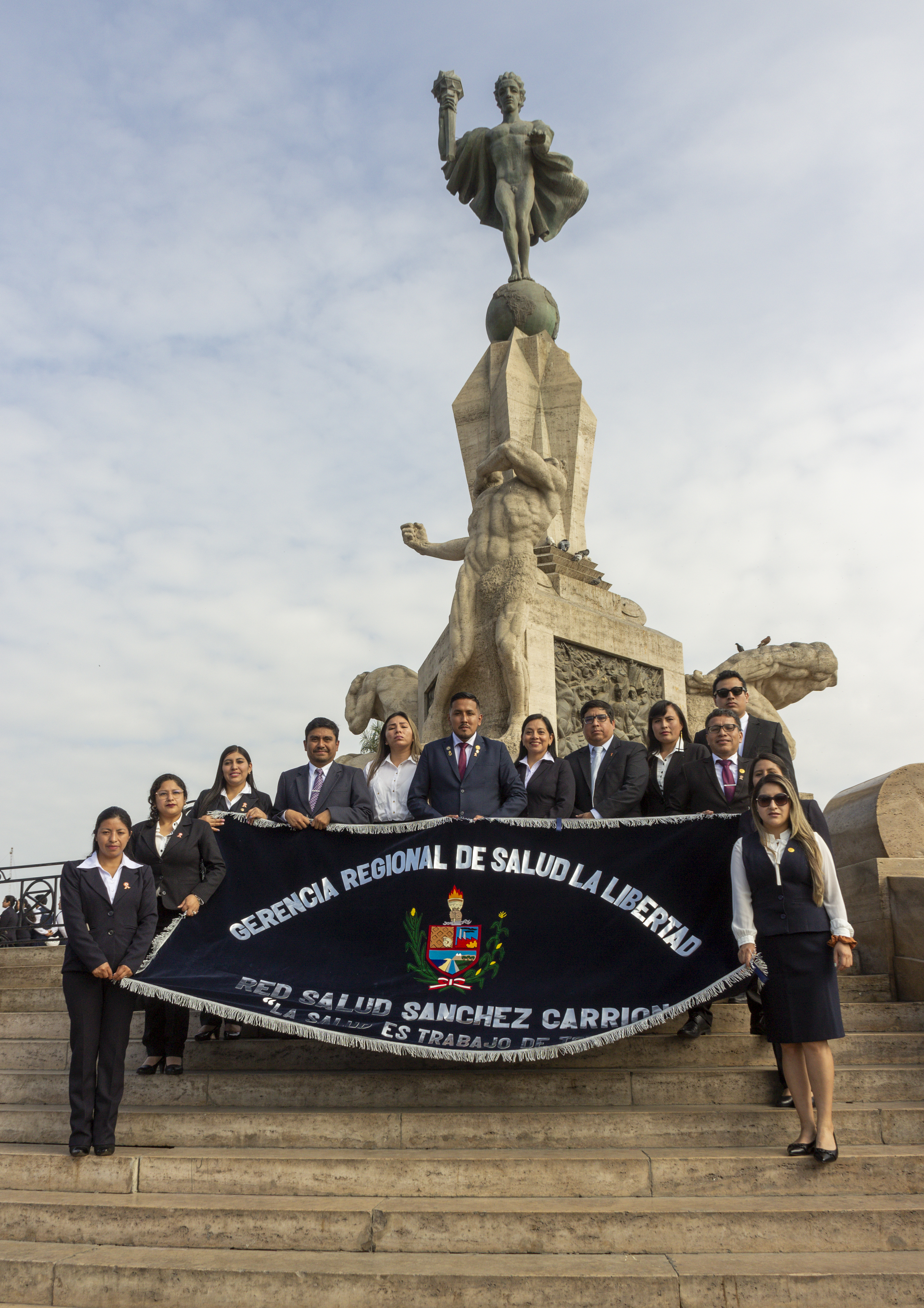 Delegación de la Red de Salud Sánchez Carrión posando para el recuerdo frente al monumento a la libertad en la plaza de armas de Trujillo