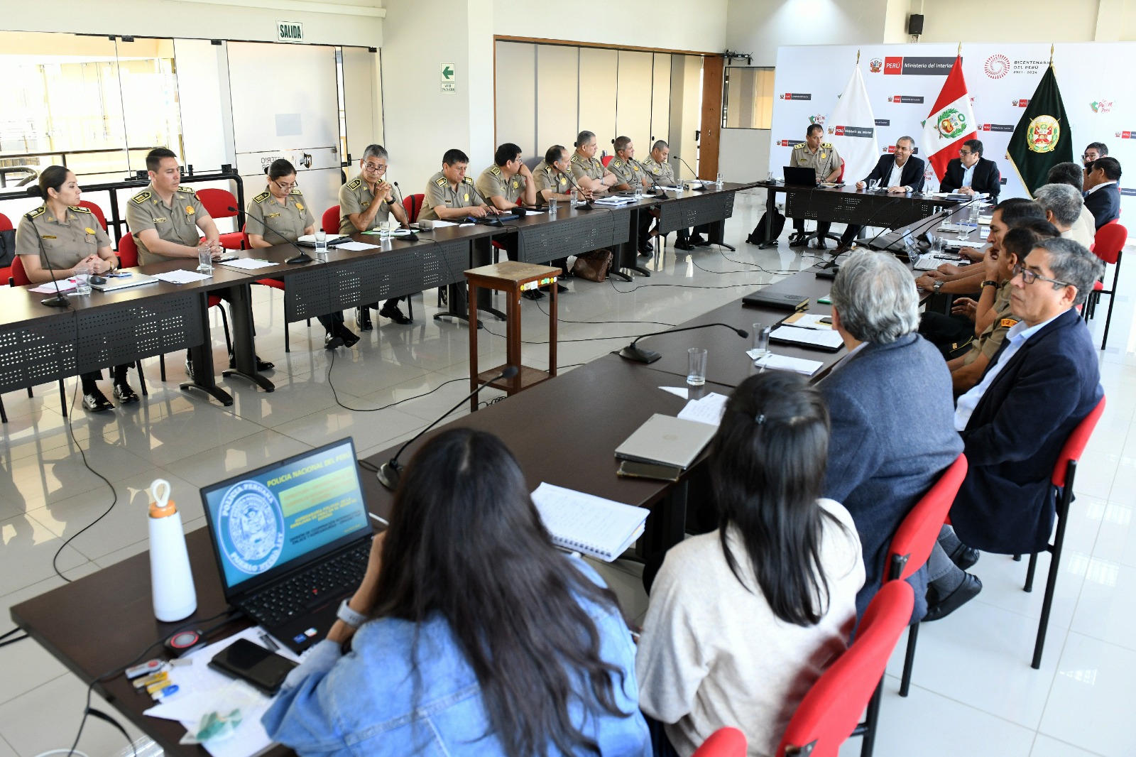 En el marco del fortalecimiento de la función policial, el ministro del Interior, Vicente Romero Fernández, se reunió hoy con los agregados policiales de nuestro país en el extranjero, quienes compartieron sus experiencias en materia de seguridad en las jurisdicciones donde desempeñaron dicha responsabilidad.
Se trata de 17 agregados policiales que acaban de regresar a Perú luego de estar dos años cumpliendo las funciones en países como Estados Unidos, Francia, Italia, España, Argentina, Brasil, Bolivia, México, Ecuador, Colombia, Chile, Panamá, Paraguay, El Salvador, Reino Unido de Gran Bretaña e Irlanda del Norte, entre otros.
Durante la reunión los oficiales expusieron sus experiencias recogidas, en el ámbito de sus funciones, en los destinos a los cuales fueron acreditados, además de dar a conocer la forma de trabajo, la formación policial, capacitación y reglamentos de las instituciones policiales con las cuales interactuaron.
“Les agradezco mucho por su presencia en esta reunión. El conocimiento y la experiencia son cosas que van de la mano, pero no tienen éxito si no se comparten y este es el objetivo de hoy. Siempre hemos trabajado con puertas abiertas y por eso estamos dispuestos a escuchar sus propuestas, sugerencias y mejoras que ayuden a fortalecer la función policial y, con ello, la vida de muchísimos peruanos”, indicó el ministro.
Refirió que es muy importante intercambiar experiencias para replicar lo bueno y aprender en base a lo que funciona mejor en otros países, como en lo relacionado a la
capacitación y especialización en materia de formación de oficiales, suboficiales y cadetes, especialmente en las áreas de seguridad ciudadana
A la reunión desarrollada esta mañana en la sede ministerial, también asistieron el jefe de gabinete de asesores Jaime Reyes y el general PNP Eduardo Tristán, Director de Asuntos Internacionales de la Policía Nacional del Perú.