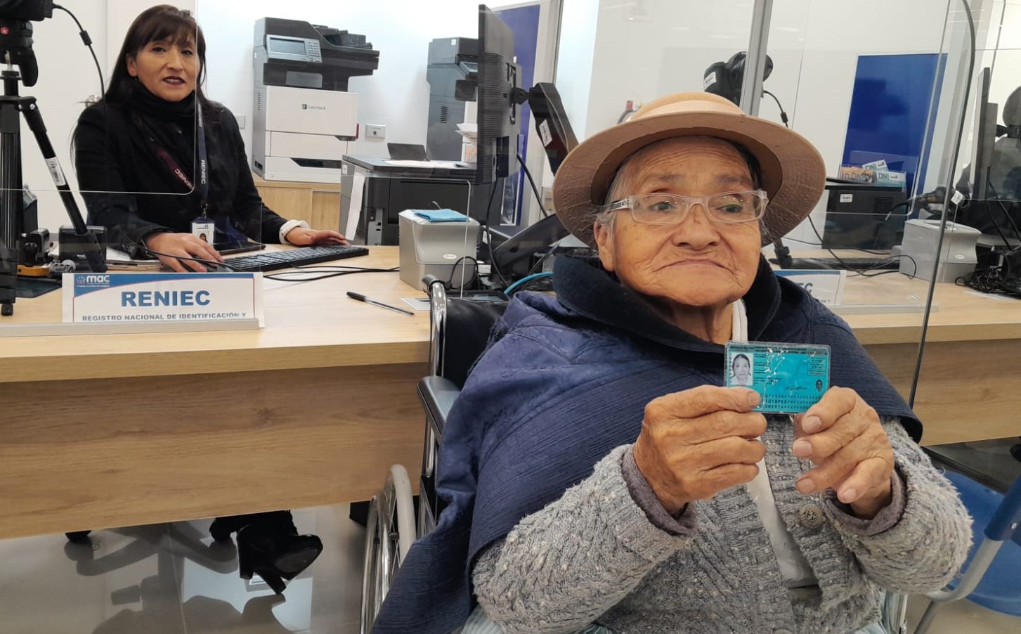 Adulta mayor mostrando su DNI en una oficina del Reniec