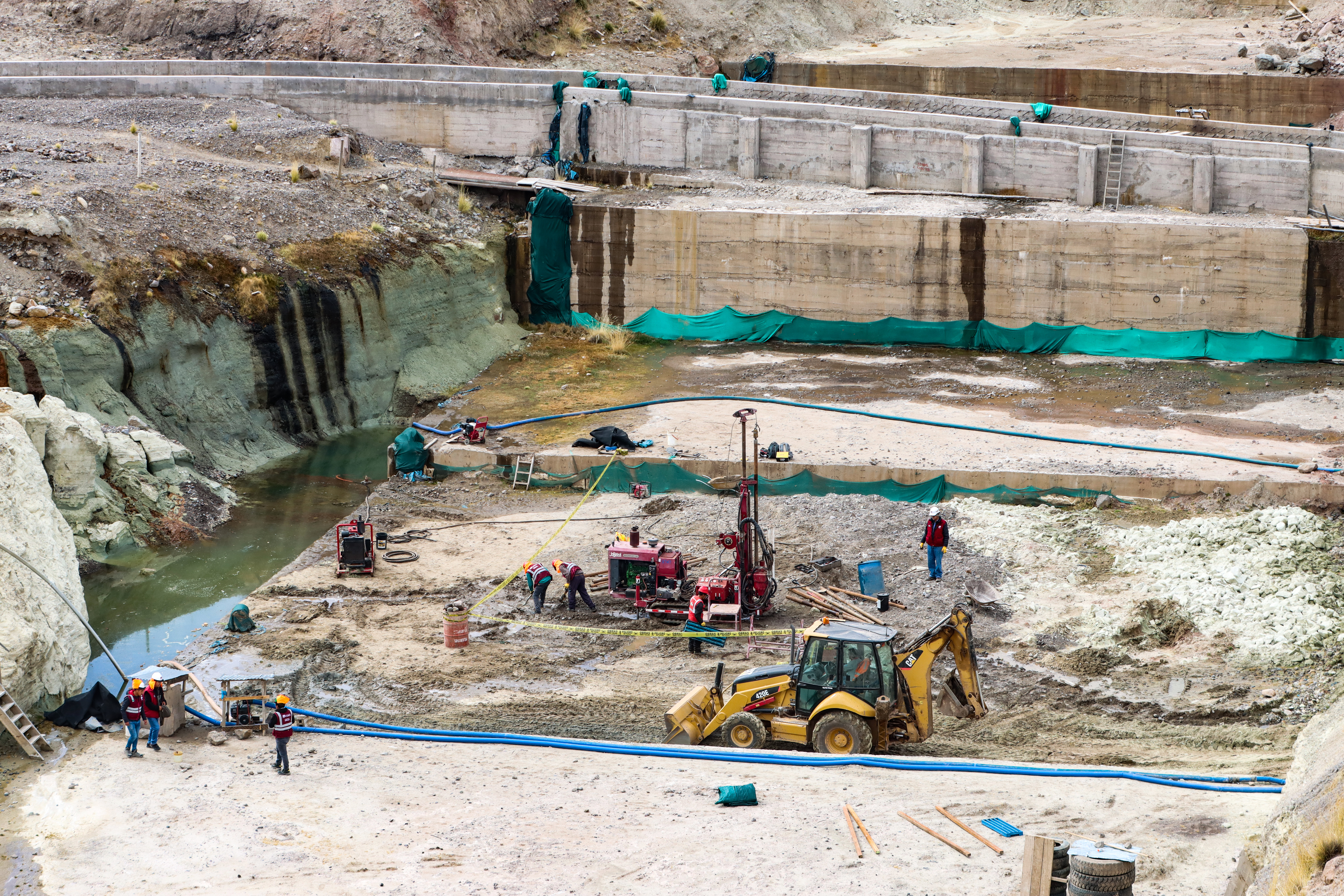 Plan MERISS brazo ejecutor del Gobierno Regional Cusco, por intermedio de su Dirección de Infraestructura Hidráulica – DIH, a cuyo frente se encuentra el Ing. William García Parra, realiza trabajos de perforación diamantina en el subsuelo de la presa Quisco, ubicada en el distrito de Alto Pichigua, provincia de Espinar con la finalidad de establecer la unión de los valores del comportamiento del subsuelo debajo del bloque que se ha vaciado hace cuatros años. Estos trabajos lo ejecutan con personal especializado, a la fecha han alcanzado una perforación de 50 metros de profundidad las muestras serán llevadas a los laboratorios de la Universidad Católica de la ciudad de Lima para determinar los resultados.
Al ser requerido el Ing. William García Parra, manifestó: Bajo esta dirección de infraestructura hidráulica venimos realizando trabajos de perforación diamantina en el flanco izquierdo de la presa Quisco, el objetivo fundamental de estos trabajos es ratificar los valores de la capacidad de carga del subsuelo, donde se puede apreciar con la primera perforación que va alcanzar los 50 metros de profundidad y posteriormente realizaremos otras 03 perforaciones con el mismo propósito de determinar las propiedades físicas del subsuelo de la presa el cual nos llevará trabajos de una semana.
Una de las finalidades de este trabajo es la ratificación de la unión de los valores del comportamiento del subsuelo debajo del bloque que se ha vaciado hace cuatros años que tiene 3 metros de altura en este trabajo momentáneo en el momento tiene 03 metros de altura, con esta actividad cumpliremos con las normativas de la Contraloría General de la República, puesto que ellos observaron que había la necesidad de realizar 04 perforaciones en esta infraestructura que contará con una altura de 30 metros, para un volumen de 8 millones de metros cúbicos de agua. Sentencio el funcionario del Plan MERISS.
DATO: Las perforaciones en la geología y la geotecnia, sirve para obtener información precisa sobre la composición y estructura del suelo y la roca, lo que es fundamental para la planificación y el diseño del proyecto de riego y obras civiles a gran escala como realiza Plan MERISS.
