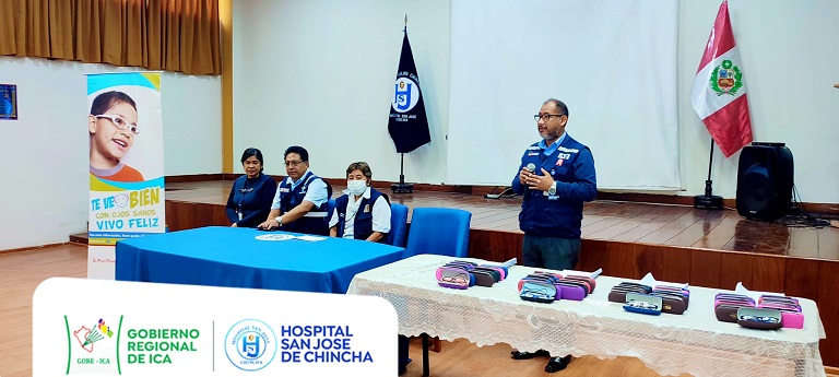 En un auditorio el representante del INO dirige la palabra a padres y niños beneficiados con la donación de lentes.