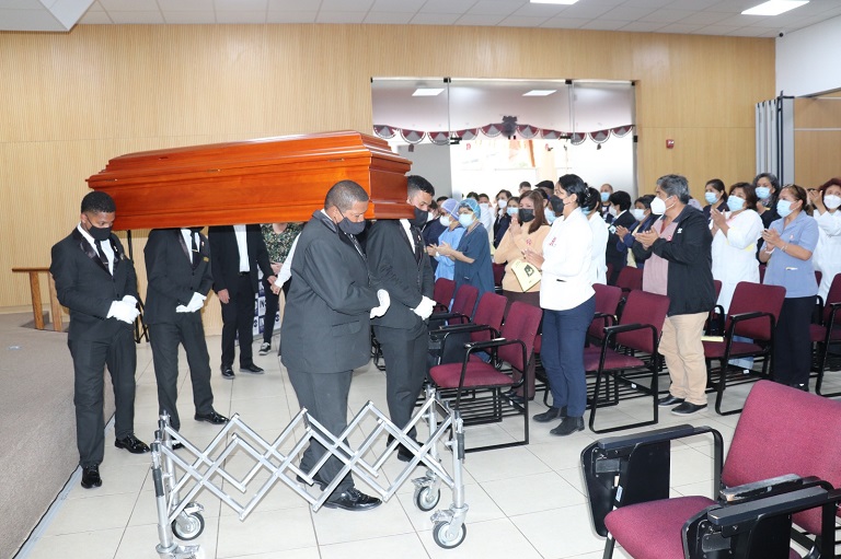 El féretro, en hombros de los cargadores, se apresta a salir del auditorio del INO recibiendo el aplauso de despedida de todo el personal congregado