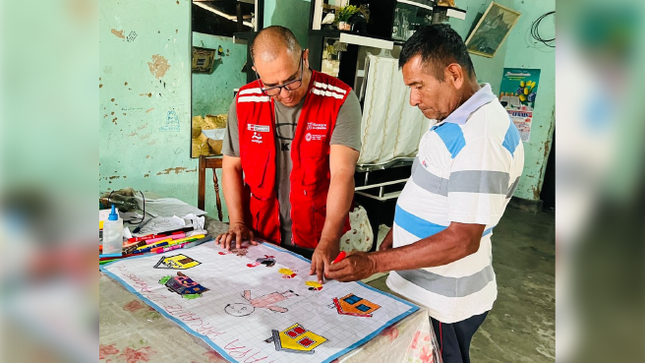 Trabajador del Programa Nacional CONTIGO junto a un autorizado mostrando un papelote de lo trabajado