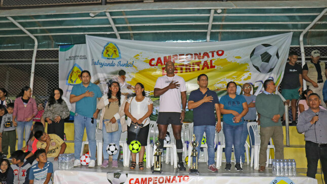 Autoridades municipales cantando el himno nacional en la inauguración del campeonato distrital   