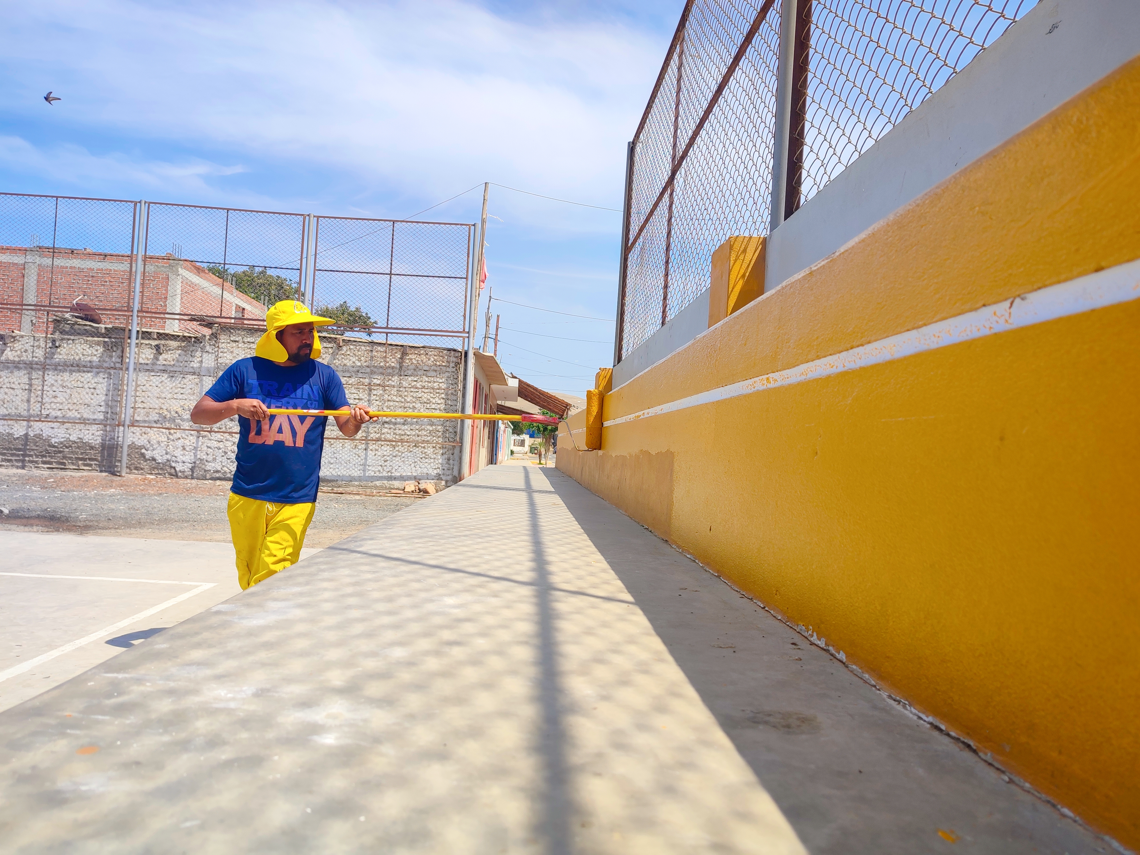 Personal edil pintando gradería de losa deportiva