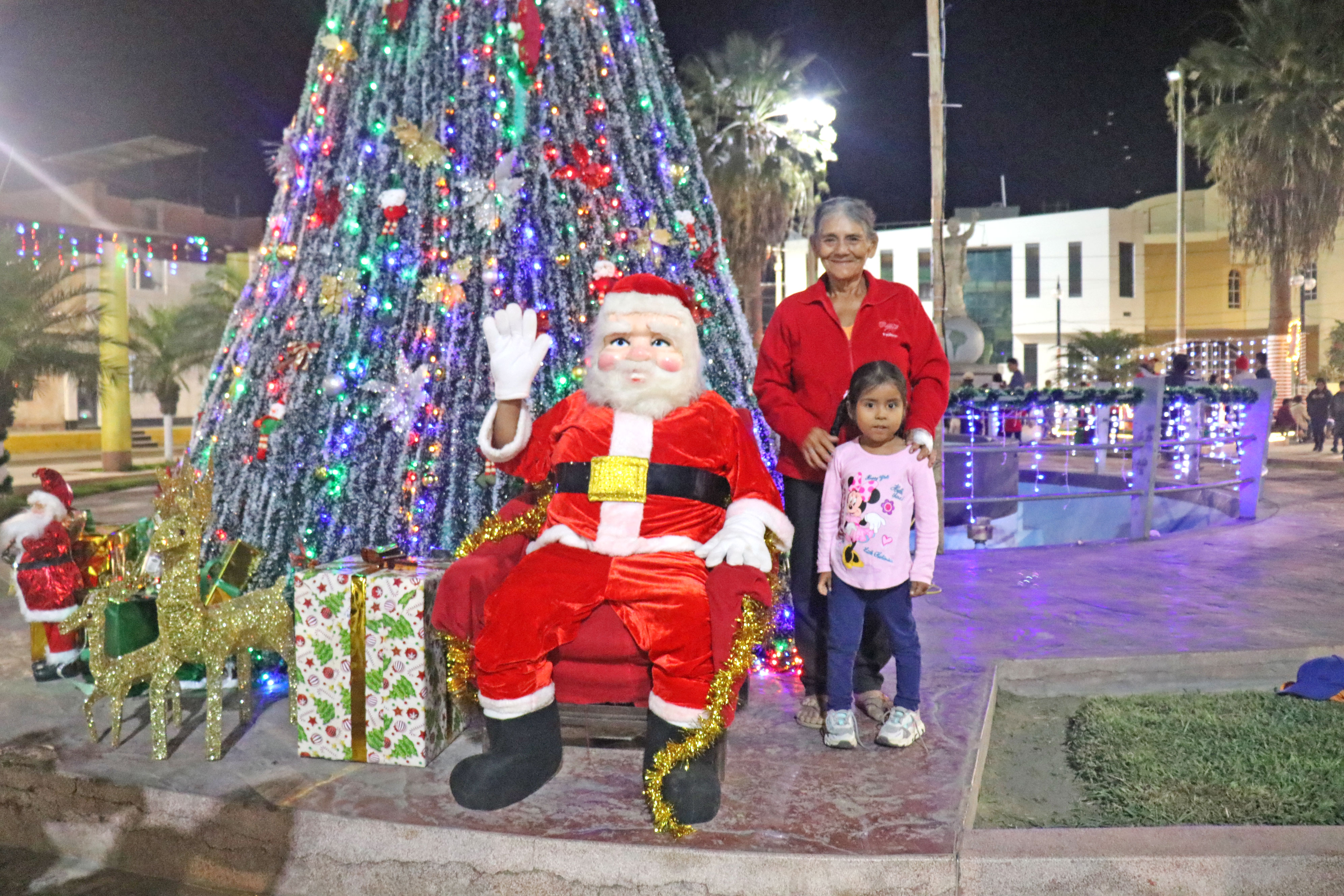 Familia junto a papá Noel en el árbol de Navidad 