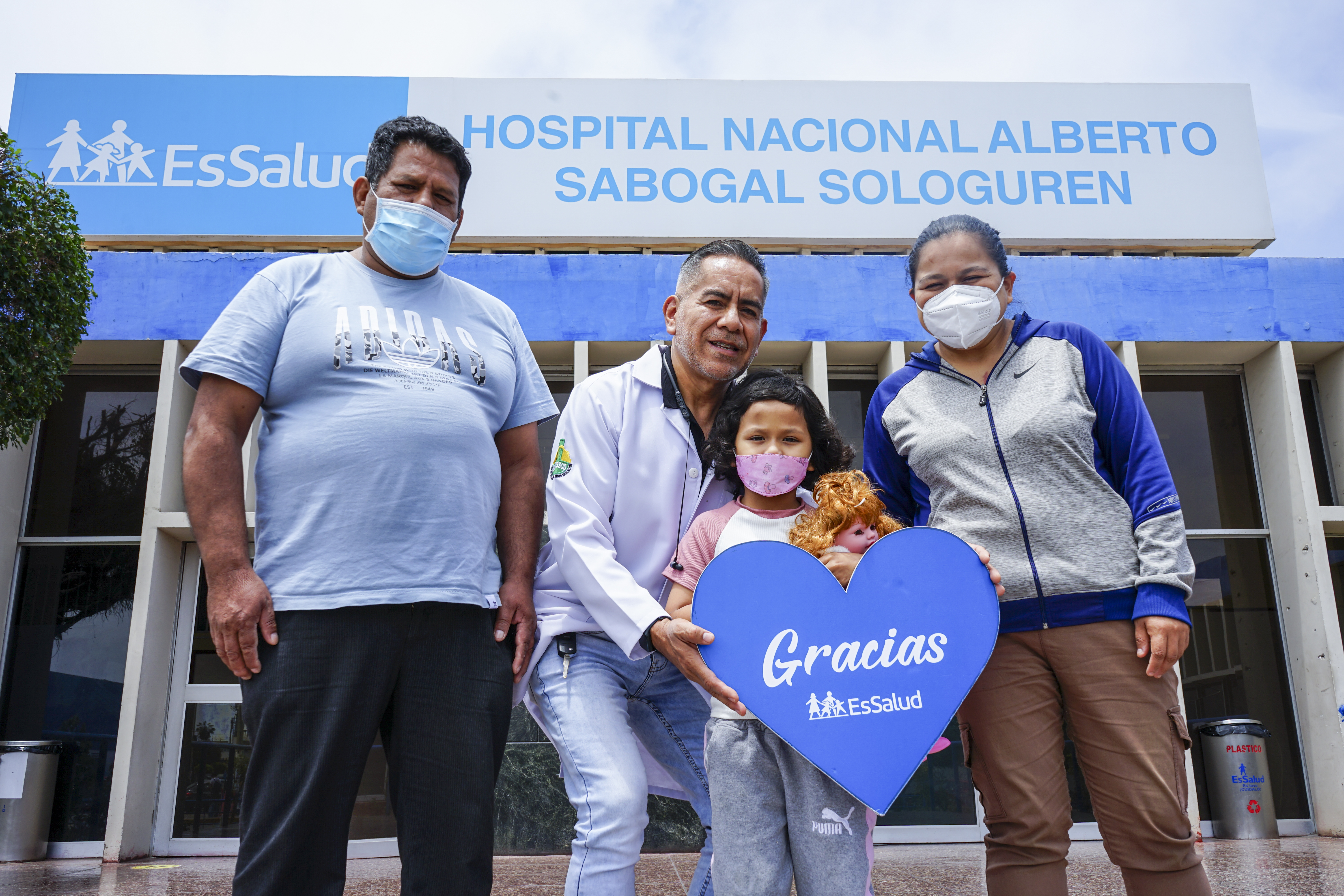 Familia alegre reunida frente al hospital