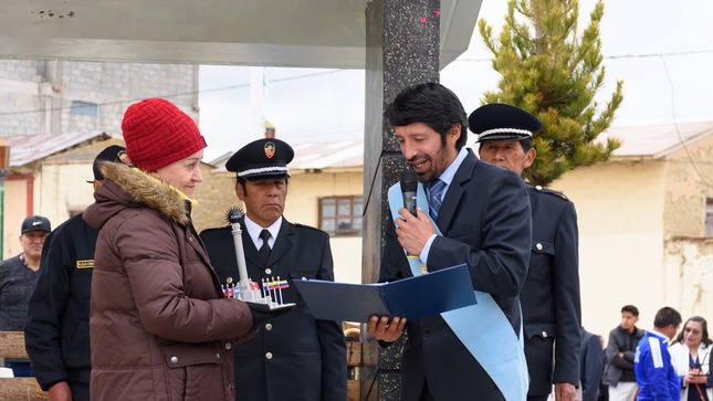 Se puede apreciar un momento significativo donde el alcalde Elio Zeballos Meza está entregando un reconocimiento a Rosalba Gallo