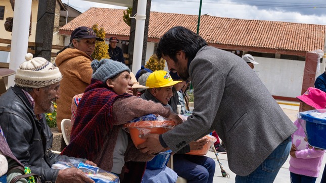 El Alcalde Elio Zeballos Meza entrega canastas a personas adultas, generando sonrisas y agradecimiento. La escena refleja un gesto de solidaridad y cuidado comunitario