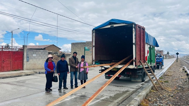 La imagen muestra al alcalde de Junín junto a tres personas, cerca de materiales de construcción entregados para el centro poblado de Rayannioc - Rucubamba. La escena refleja un compromiso visible hacia el desarrollo local, destacando la colaboración entre la municipalidad y la comunidad.