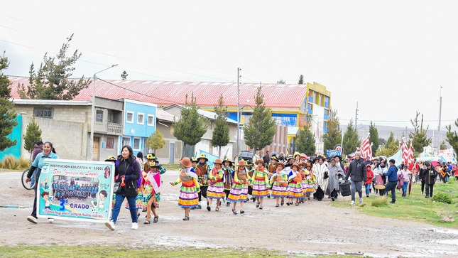 La imagen captura la energía y diversidad del pasacalle, con participantes vistiendo trajes tradicionales mientras realizan sus danzas. El colorido y la armonía visual reflejan la riqueza cultural del evento, creando una estampa festiva llena de alegría y dedicación. La imagen transmite la vitalidad y conexión con las tradiciones que define el pasacalle comunitario