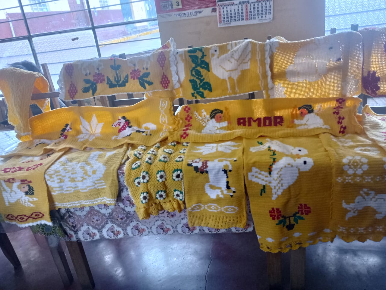 La imagen muestra tejidos a crochet en Ulcumayo, reflejando la destreza artesanal y la riqueza cultural. La comunidad admira las creaciones, mientras Susana Chuco Chaccha y PANTBC expresan gratitud. La foto captura la conexión comunitaria a través del arte del crochet.