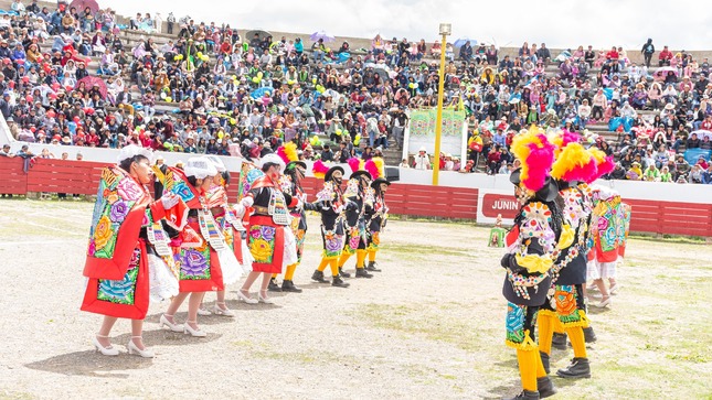 En la imagen, la alegre danza de la "Chonguinada" llena de vitalidad la celebración del Día de los Solteros y Solteras en Junín. Los participantes, con trajes coloridos, sonríen mientras el público se une en aplausos, creando una atmósfera festiva y contagiosa.