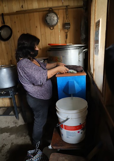 Madre de familia haciendo uso del filtro domiciliar