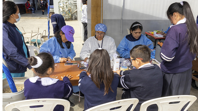 Imagen de la campaña de salud en escuela donde el personal de salud aiende a los escolares.