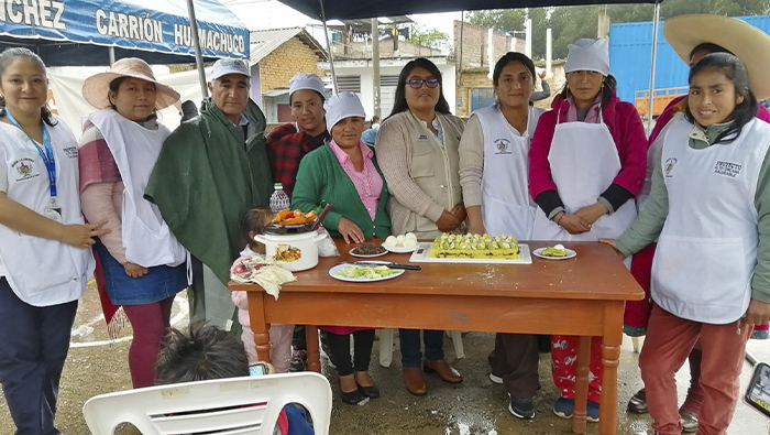 Imagen de la demostración de platos nutritivos del personal de salud a los niños y mamás.