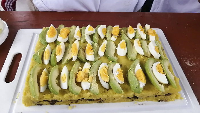 Imagen de la demostración de platos nutritivos del personal de salud a los niños y mamás.