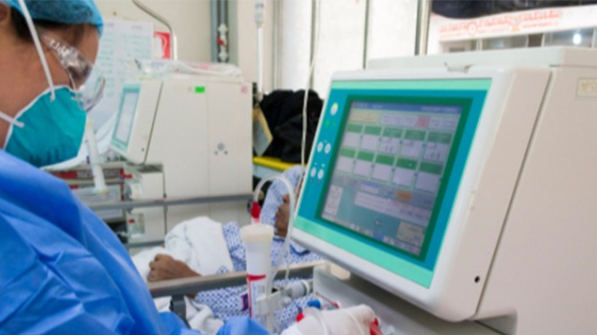 Foto de un personal de salud revisando un monitor de signos vitales en una sala de UCI