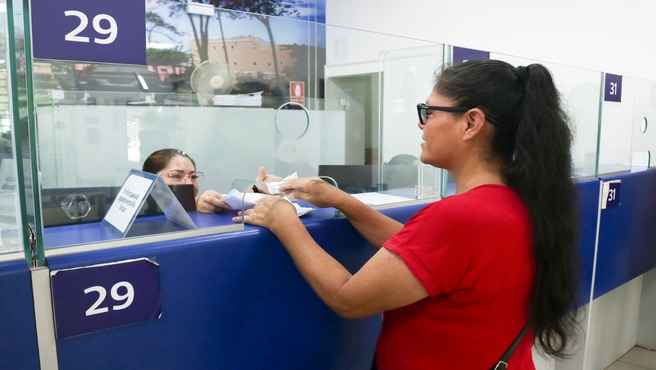 Vecina pagando su impuesto predial
