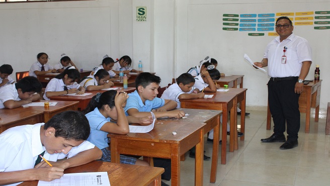 Profesor Manuel Ramirez verificando el buen desempeño de los estudiantes en la evaluación.