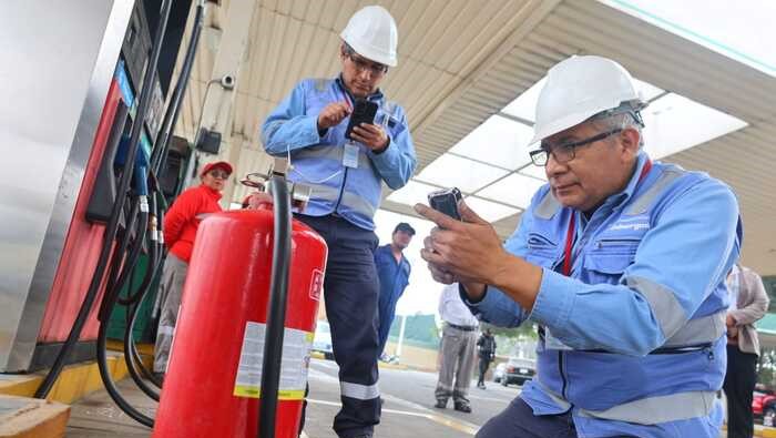 Dos supervisores de Osinergmin inspeccionan que un extintor de incendios cumpla con la normativa