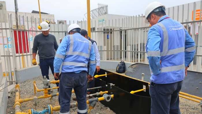 Dos supervisores de Osinergmin observan tuberías de gas natural en un grifo