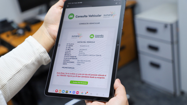 Foto de vista de la plataforma Consulta Vehicular en un tablet mostrada por una persona