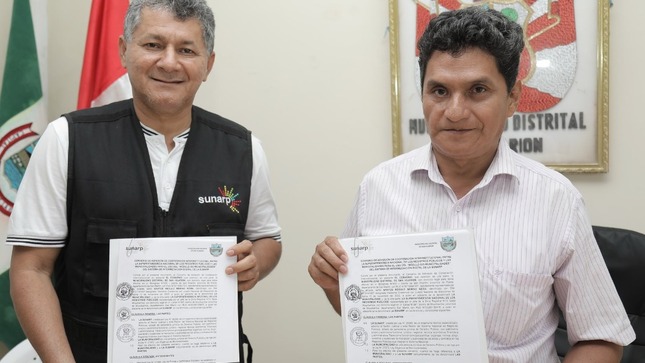 Foto de Funcionario de Sunarp Moyobamba y de la Municipalidad de San Hilarión muestran documentos del convenio firmado