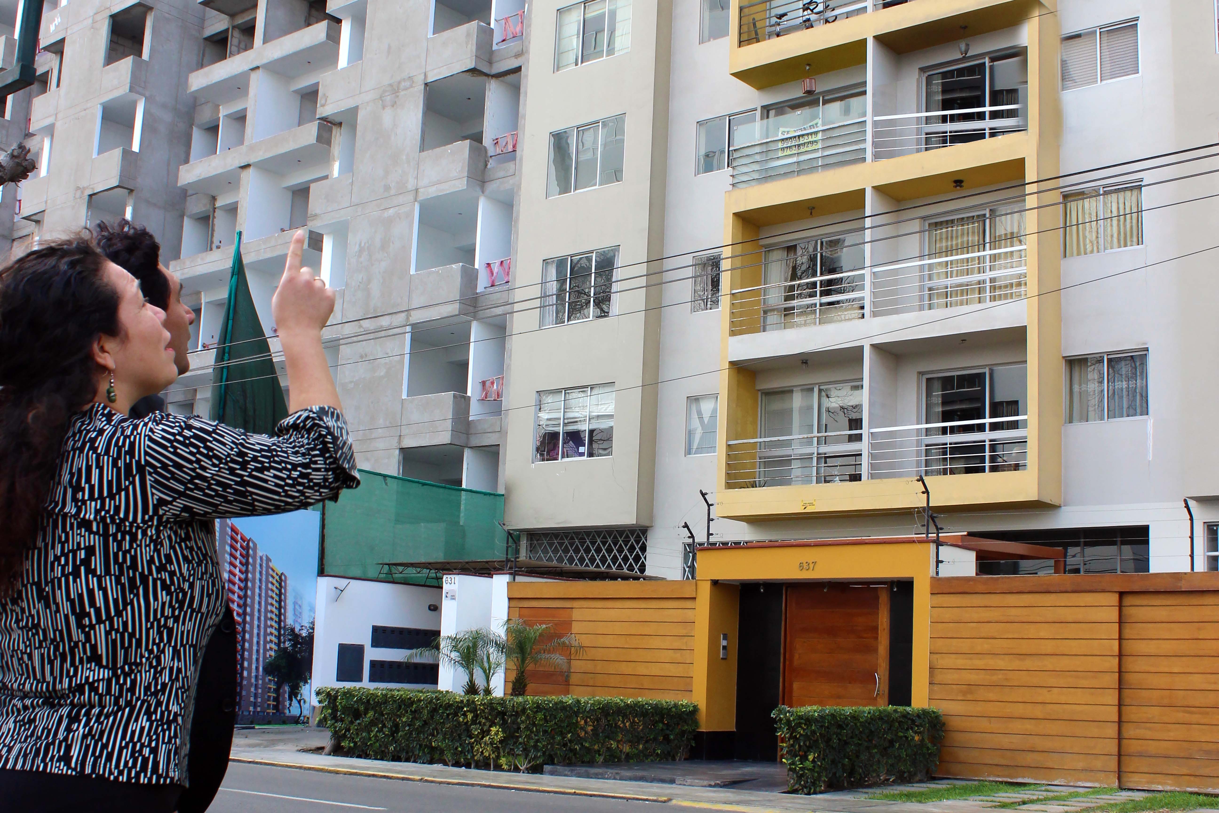 Foto de Hombre y mujer observan edificio de departamentos desde la calle