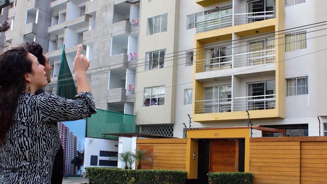 Foto de Hombre y mujer observan edificio de departamentos desde la calle