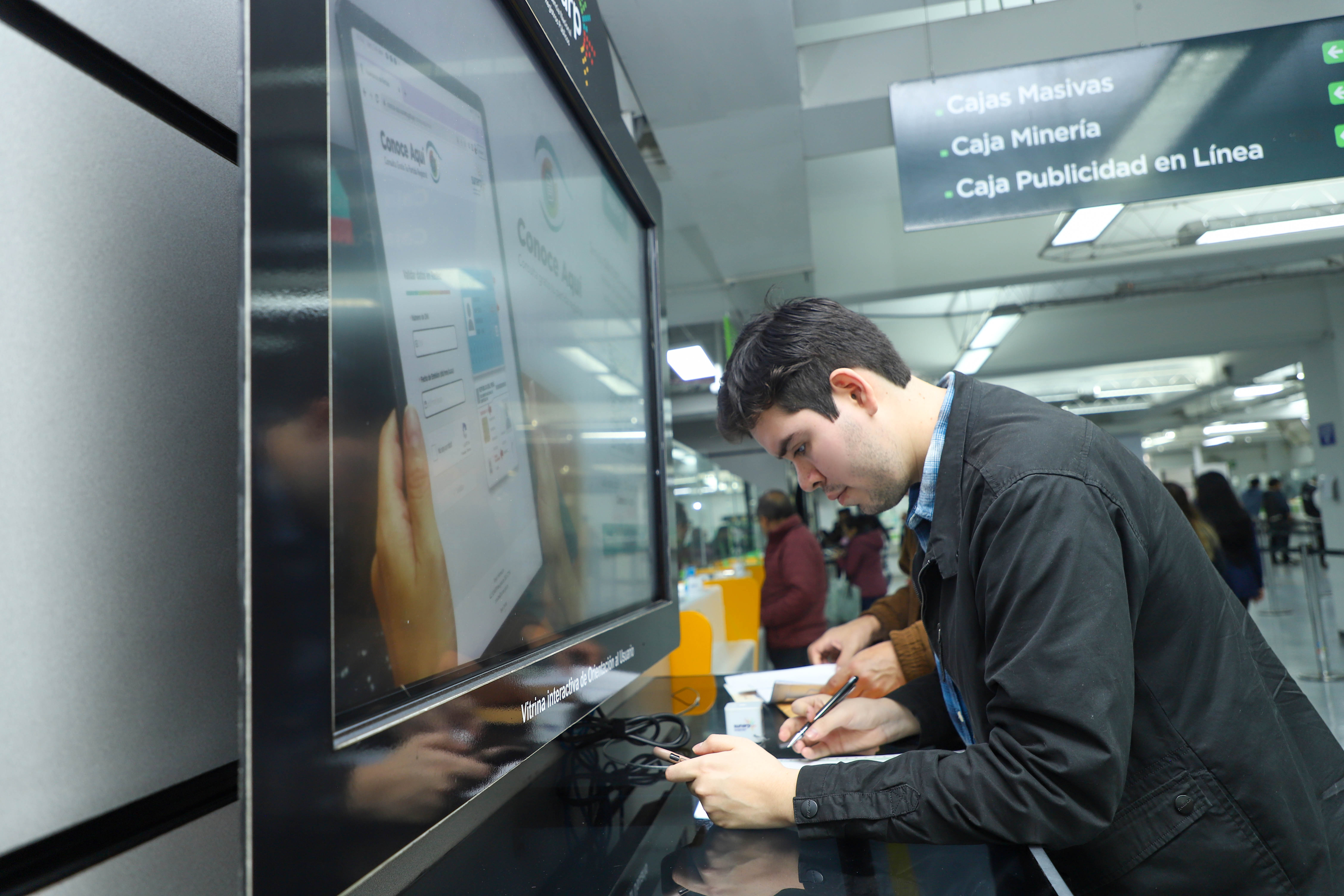 Foto de Hombre llenando formato de trámite en oficina de Sunarp