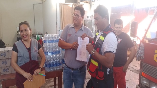 JORGE COBOS ANGULO Gerente de la Sub Región Huallaga Central entrega el acta de donación al representante de los Bomberos de Bellavista.