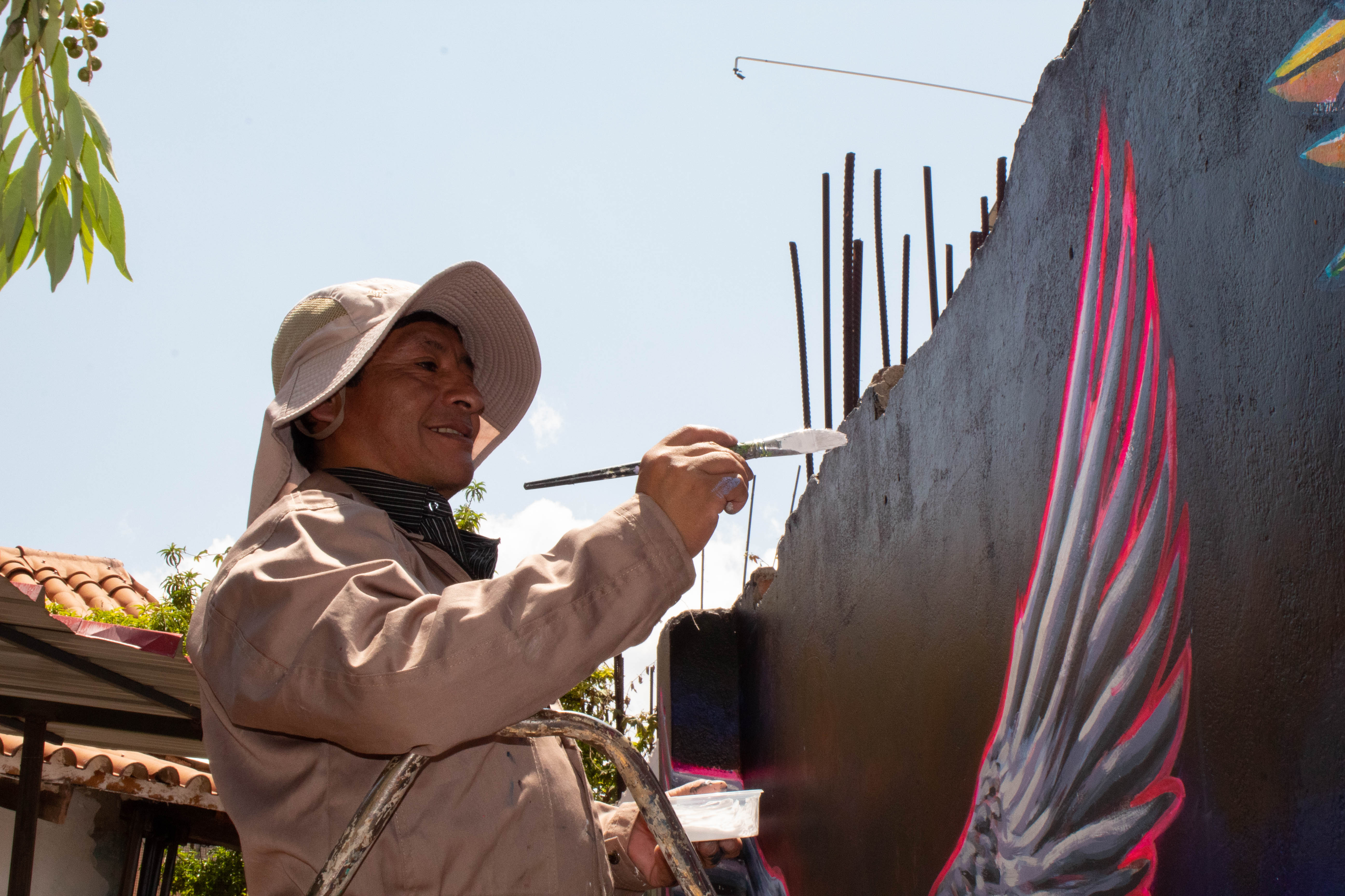 Profesor Marcial Quispe en el ejercicio de su profesión, ultimando detalles al mural