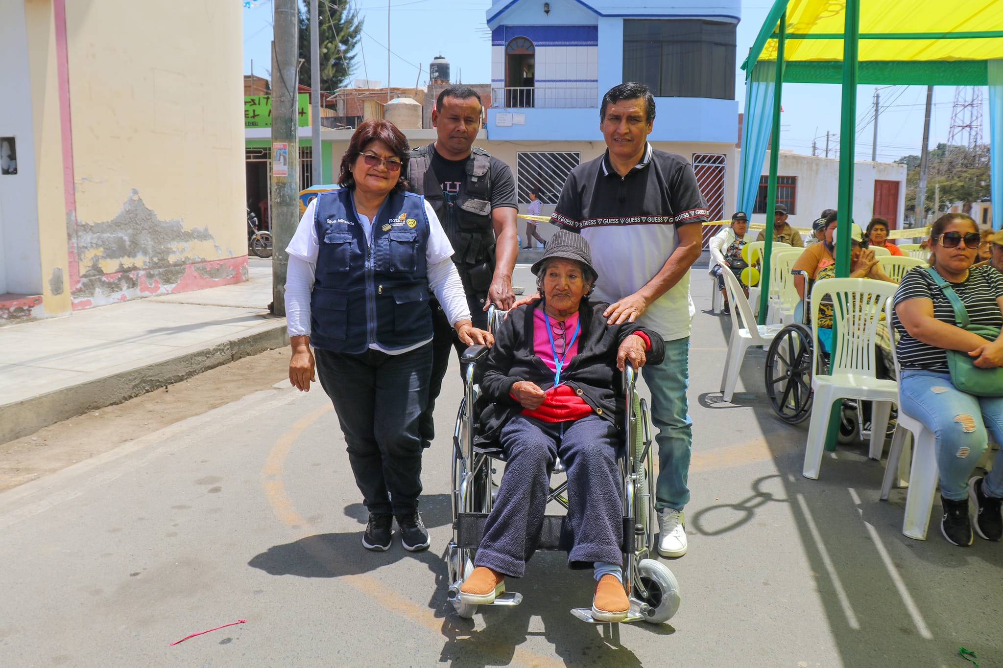 Representante del Rotary entregando silla de ruedas