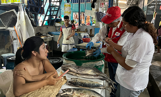 Especialista de DIREFI junto representante de SANIPES y comerciante.