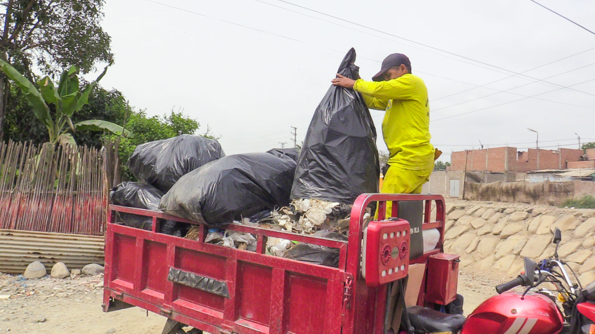 Montículos de basura vaciado en la motocarguera