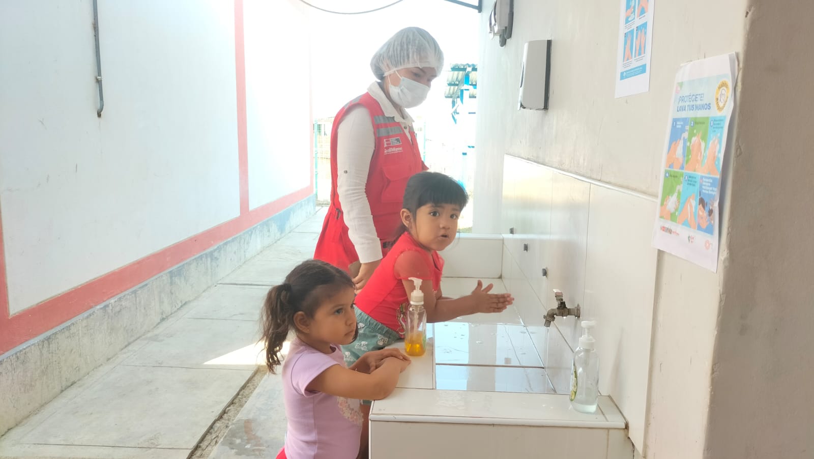 Niña aprende la práctica del lavado de manos.