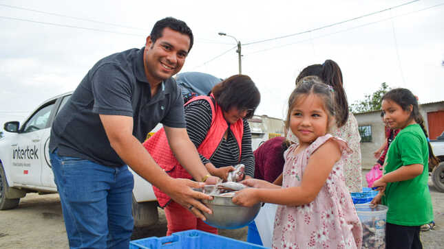 Gerente municipal dando pescado a una niña