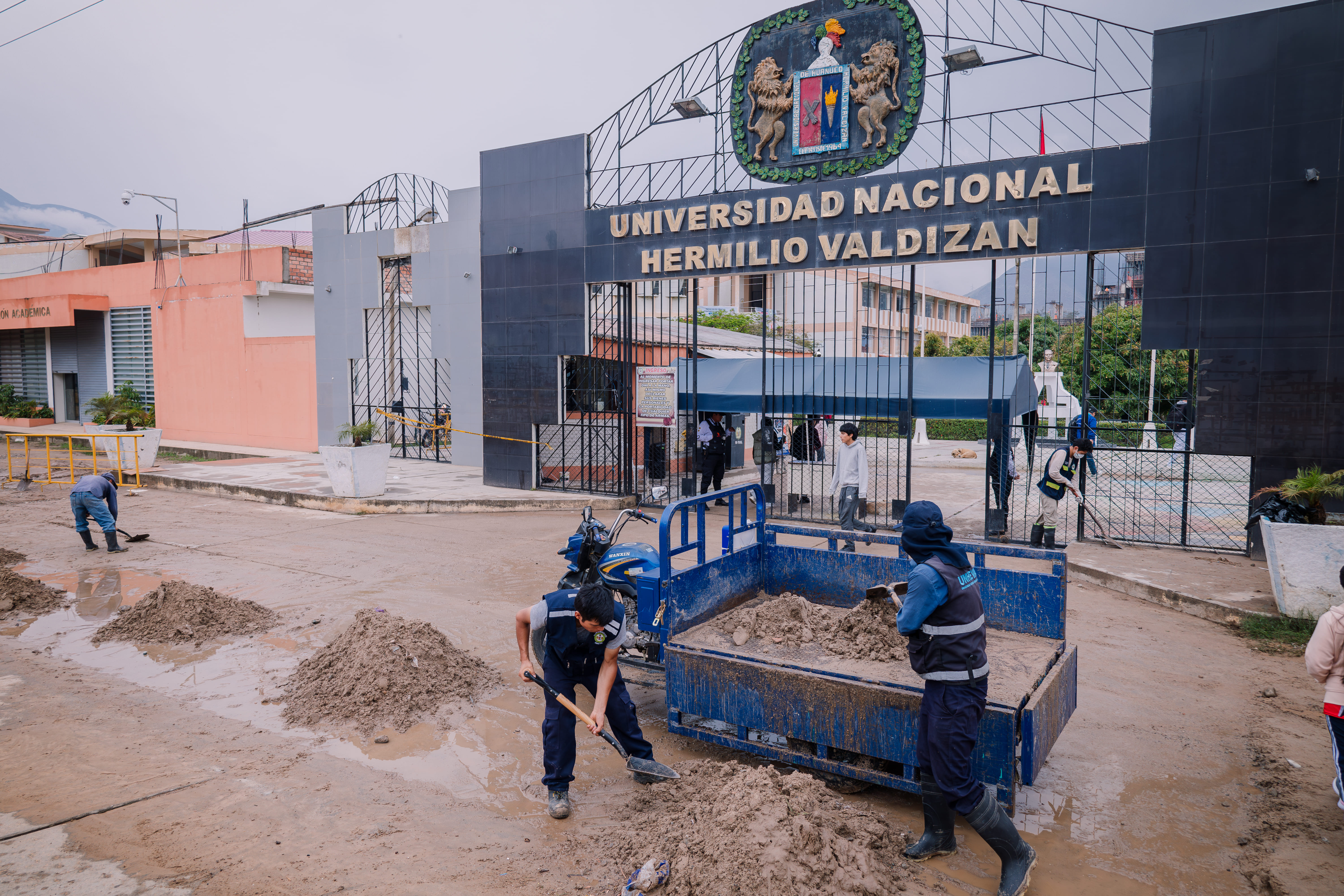 Personal de Servicio Generales limpiando la puerta principal de la UNHEVAL