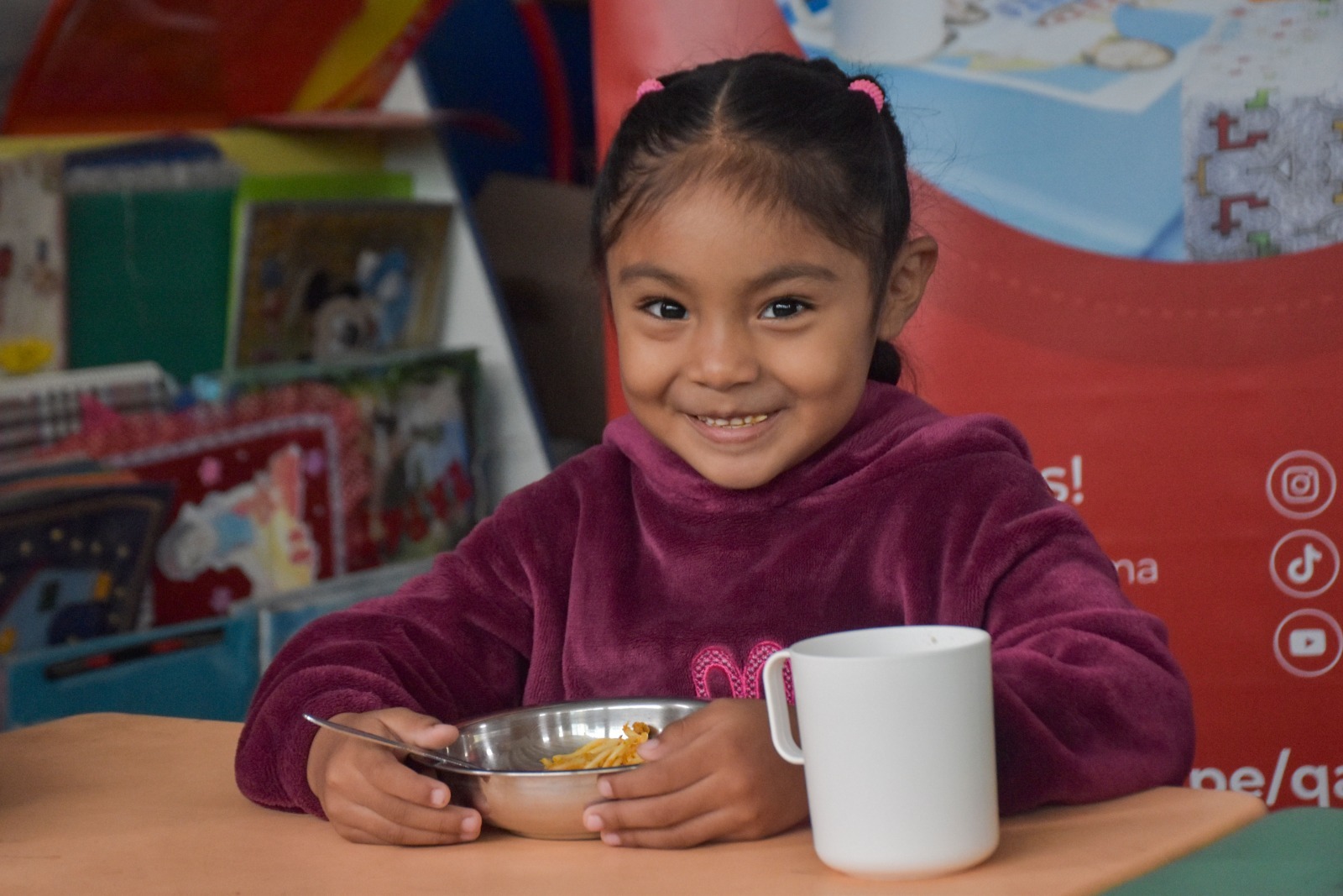 Niña consume alimento feliz.