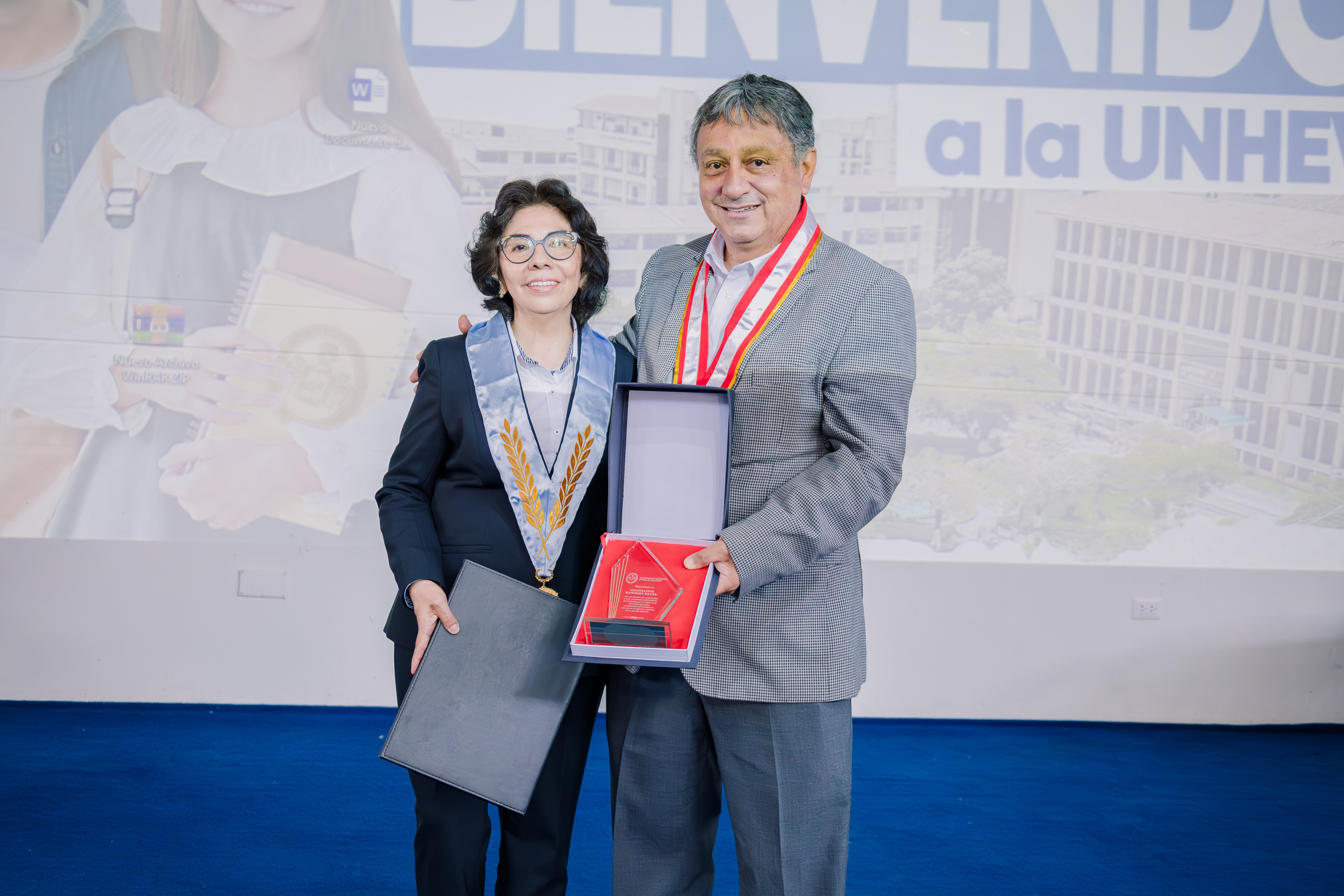 Rector haciendo entrega de reconocimientos a docente