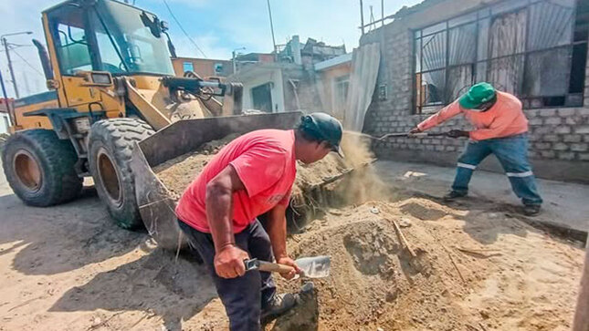Personal obrero de la comuna recogiendo desmonte de la vía pública